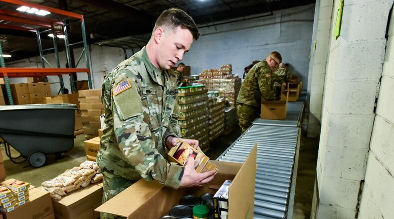 Sgt. Kennith Moss, from Hamilton, and other members of the Ohio Army National Guard pack boxes of food at Shared Harvest Food Bank Monday, March 23, 2020 in Fairfield. The Ohio Army National Guard was activated and helped pack food to be distributed to those in need throughout the area. NICK GRAHAM / STAFF