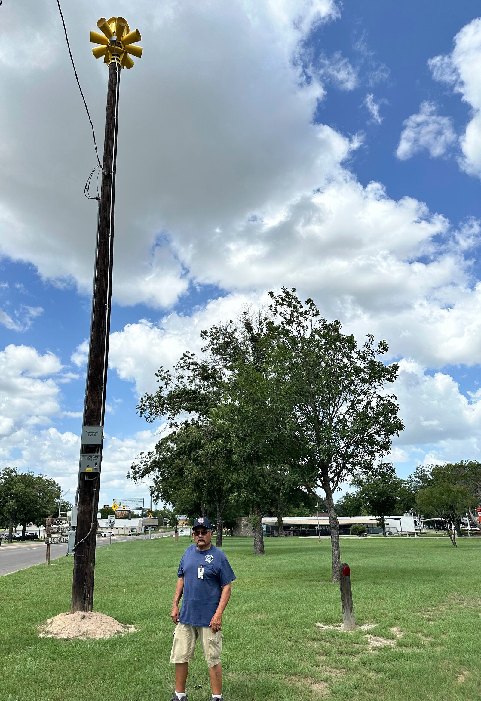 Comfort, Texas, Assistant Fire Chief, Danny Morales stands under a flash flood siren in the community's park on Thursday, July 10, 2025. (AP Photo/Sean Murphy)