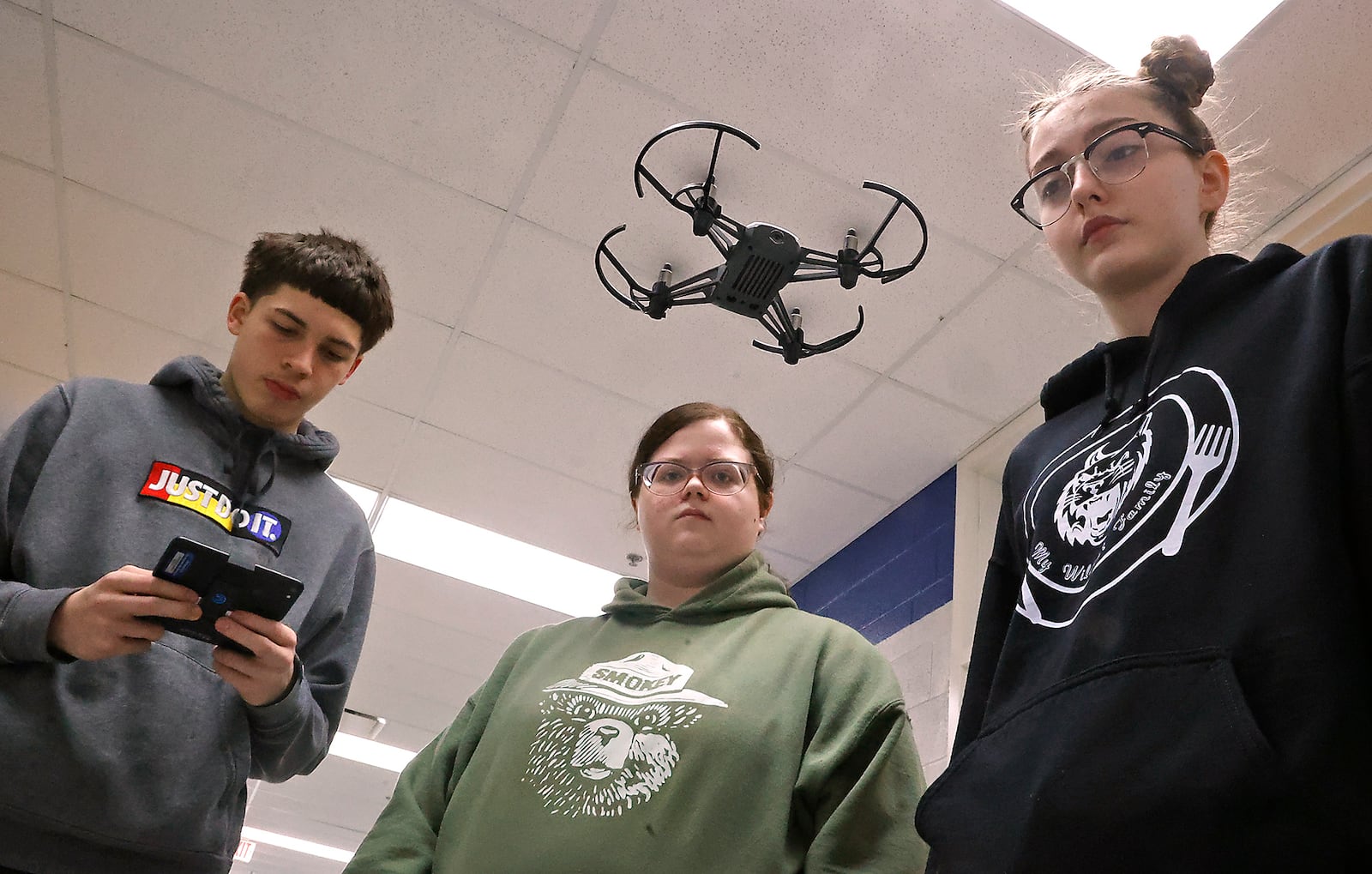 Cierra Hill, right, and Kylie Gaurley watch as Milo Gonzalez practices flying one of the drones in the new program at the Springfield School District's School of Innovation Thursday, April 13, 2023. BILL LACKEY/STAFF