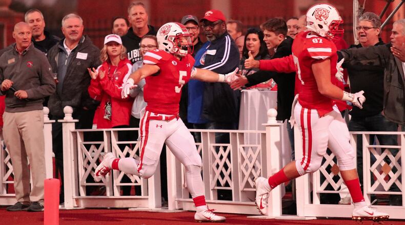 Wittenberg University junior Nick Kendall (5) and senior Noah Dehnke (87) celebrate Kendall’s 75-yard TD run with fans during the Tigers 45-3 victory over Kenyon at Edwards-Maurer Field in Springfield. The Tigers won their 17th straight regular season game. Michael Cooper/CONTRIBUTED