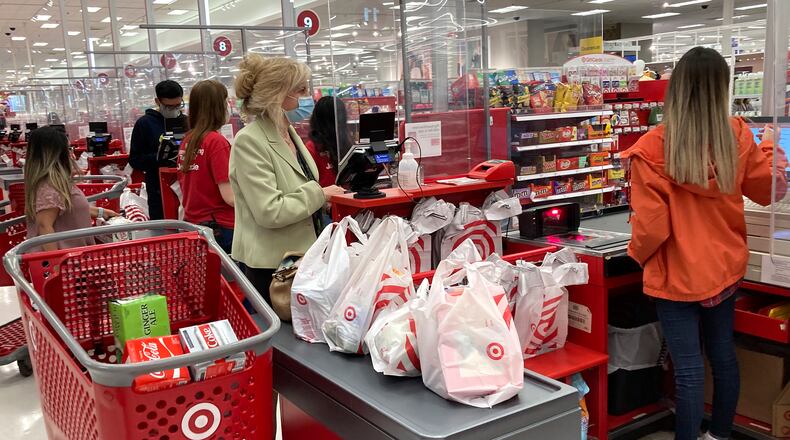 FILE - A customer wears a mask as she waits to get a receipt at a register in Target store in Vernon Hills, Ill., Sunday, May 23, 2021. (AP Photo/Nam Y. Huh, File)