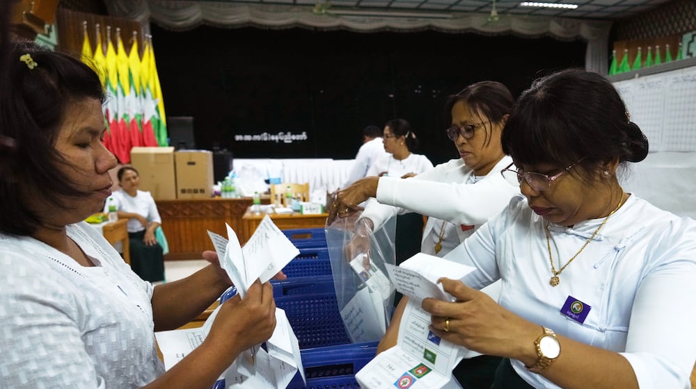 Officials of the Union Election Commission prepare to count votes at a polling station, during the first phase of general election, in Naypyitaw, Myanmar, Sunday, Dec. 28, 2025. (AP Photo/Aung Shine Oo)