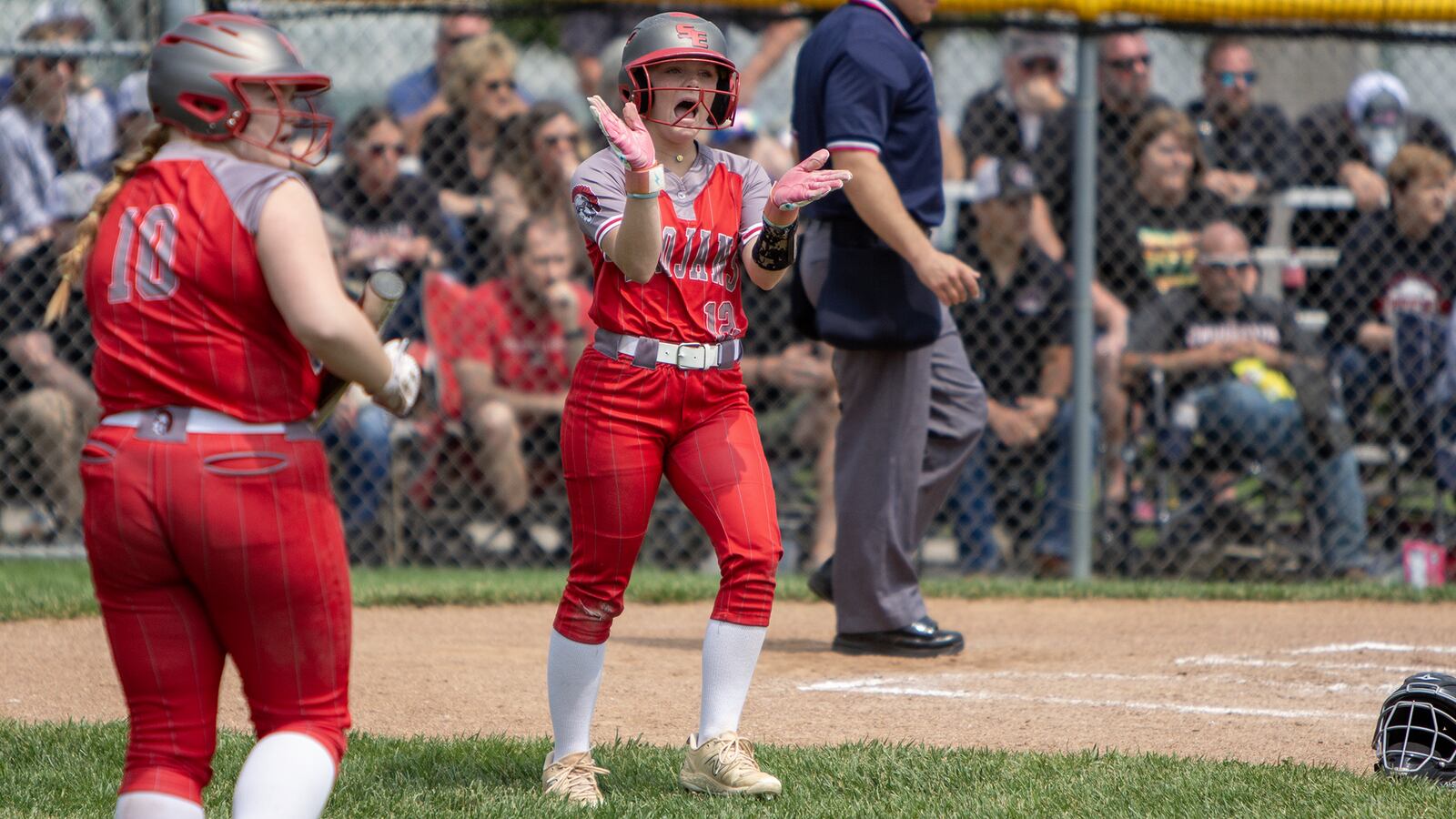Southeastern's Allie Lewis gives a shoutout to Gabby McNier who singled her home in the first inning of Saturday's regional final loss to Covington at Northmont. Jeff Gilbert/CONTRIBUTED