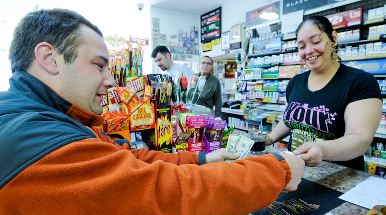 Cherezada Ghamandi sells Mega Millions tickets to Justin Smith for the $540 million jackpot at P & G Food Mart on Cincinnati Dayton Road Friday, March 30, 2012 in Middletown. Photo by Nick Graham