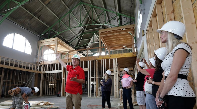 Patrick Williams leads a tour of the new COhatch Market to show investors and city officials the progress of the construction Wednesday. BILL LACKEY/STAFF