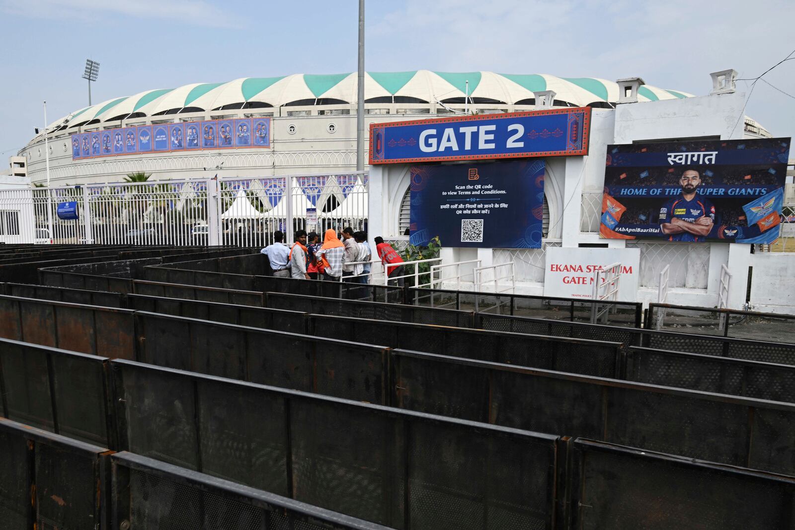 Fans wait outside a closed entrance of Atal Bihari Vajpayee Ekana Cricket Stadium after organizers suspended the Indian Premier League for one week following the escalating military tensions with Pakistan, in Lucknow, India, Friday, May 9, 2025. (AP Photo)