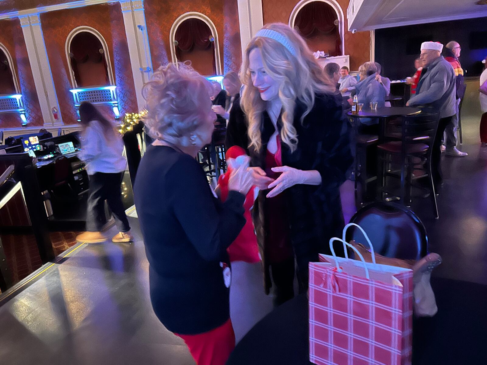 Springfield native and professional actress Marsha Dietlein accepts a gift from Ruth Addis, the mom of a friend she grew up with, at the Ohio premiere of Dietlein's new holiday film "Saint Nick of Bethlehem" at the State Theater on Saturday.
