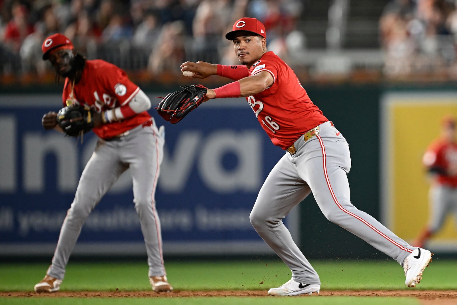 Cincinnati Reds third baseman Noelvi Marte, right, throws to first base for an out on a ball hit by Washington Nationals' Nathaniel Lowe off Reds pitcher Sam Moll during the sixth inning of a baseball game in Washington, Monday, July 21, 2025. (AP Photo/Terrance Williams)