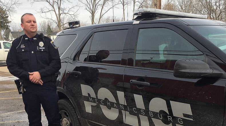 Mechanicsburg police officer, Nickolous Black Stands next to the police car that will be retrofitted to carry the new K9 dog. JEFF GUERINI/STAFF