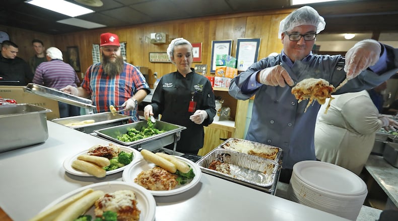 The staff from Olive Garden serves up an Italian Thanksgiving feast at the Springfield Soup Kitchen Thursday. Bill Lackey/Staff