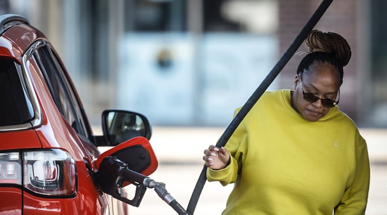 Tamika Duverglas, from Dayton, pumps gas at the UDF at Brown and Stewart Streets Wednesday December 27, 2023. Gas prices have been rising lately because of tensions in the Middle East. JIM NOELKER/STAFF
