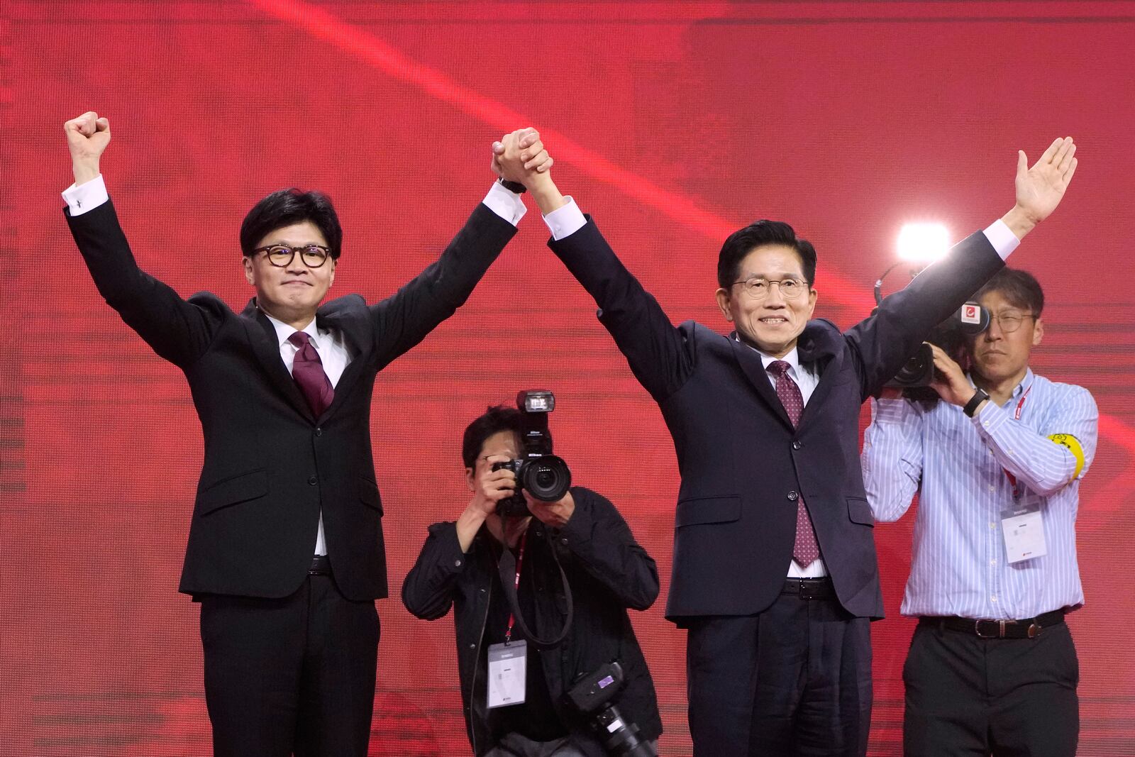 South Korea's People Power Party former leader Han Dong-hun, left, and former Labor Minister Kim Moon Soo raise their hands during a party's convention in Goyang, South Korea, Saturday, May 3, 2025. (AP Photo/Ahn Young-joon)