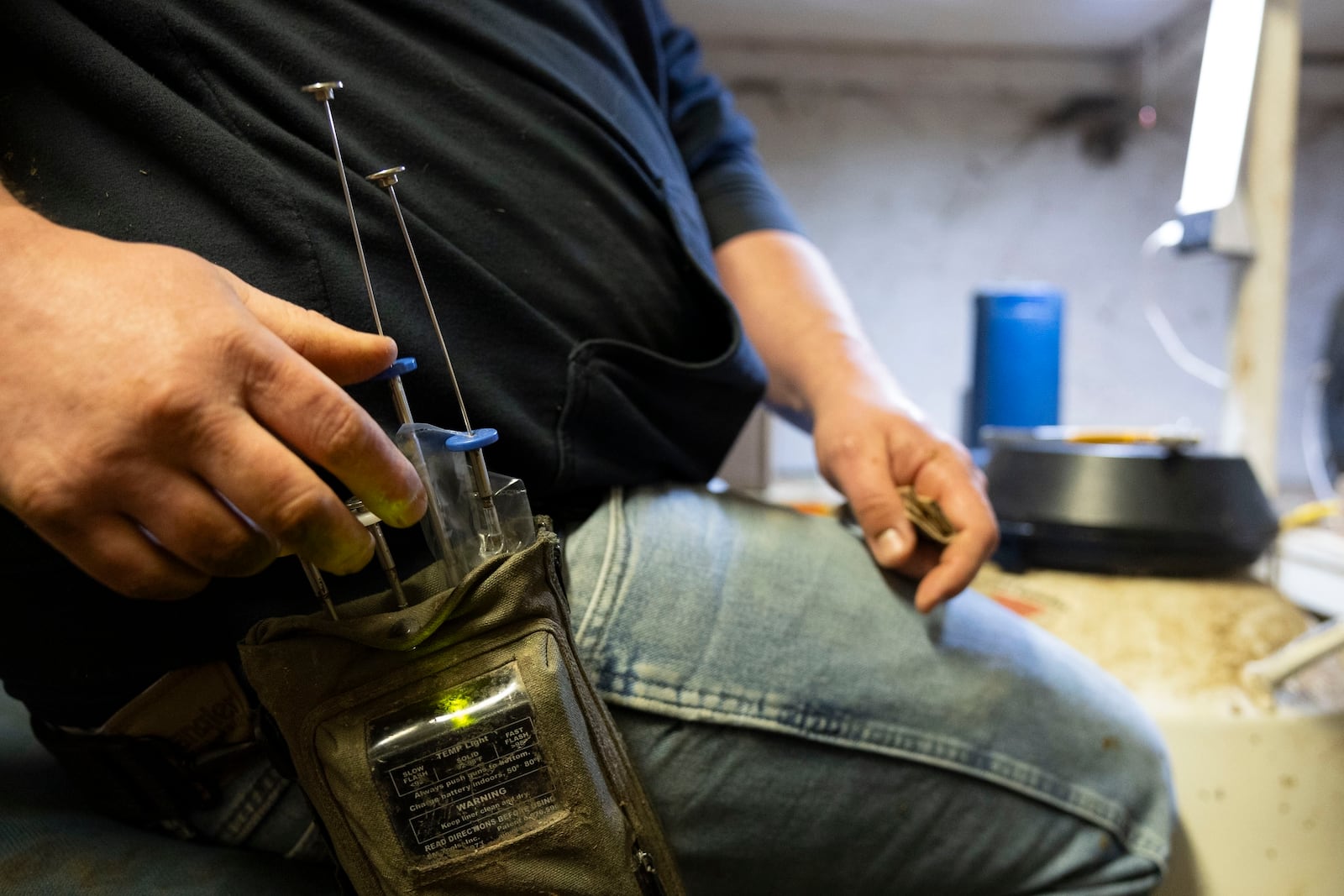 Dairy farmer Jeremy Brown prepares his tools to inseminate cows at Twin Birch Dairy on Friday, March 21, 2025, in Skaneateles, N.Y. (Caitlyn Daproza via AP)