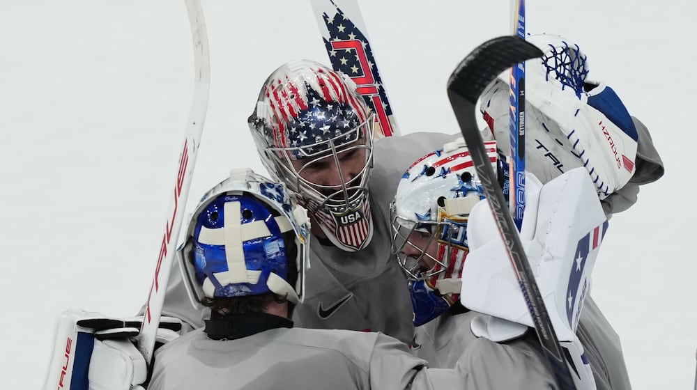 United States goalkeepers Connor Hellebuyck, Jake Oettinger, and Jeremy Swayman, gather on the ice during men's ice hockey practice at the 2026 Winter Olympics, in Milan, Italy, Sunday, Feb. 8, 2026. (AP Photo/Carolyn Kaster)