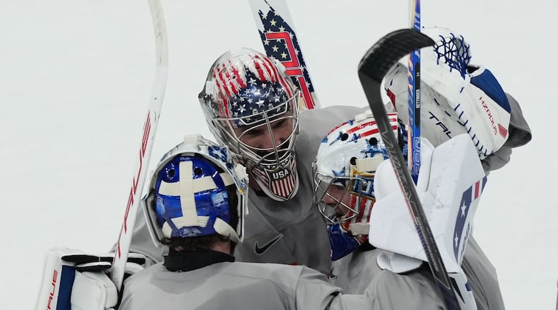 United States goalkeepers Connor Hellebuyck, Jake Oettinger, and Jeremy Swayman, gather on the ice during men's ice hockey practice at the 2026 Winter Olympics, in Milan, Italy, Sunday, Feb. 8, 2026. (AP Photo/Carolyn Kaster)