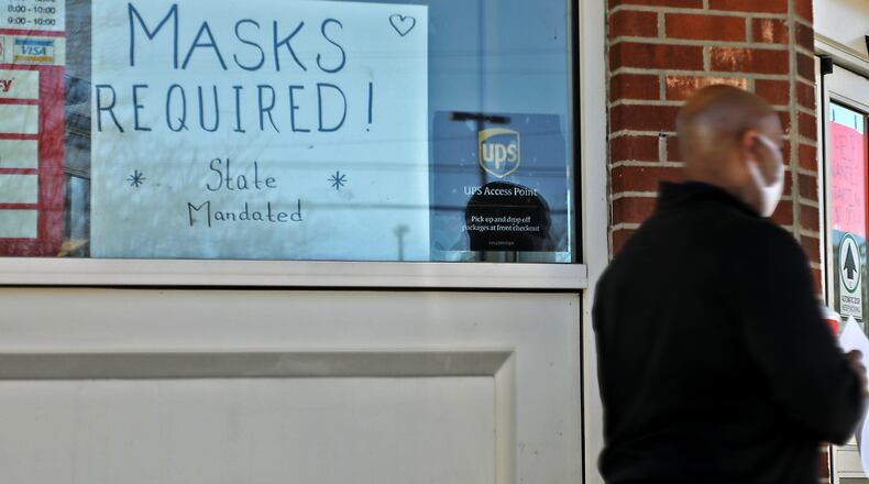 A sign lets customers know that masks are required inside by state mandate at a Springfield retail business. Gov. DeWine's mask mandate went into effect on Monday, Nov. 16. BILL LACKEY/STAFF