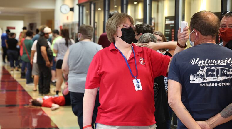 Suzanne Massie, takes temperatures before people enter the COVID vaccination clinic at Tecumseh High School. BILL LACKEY/STAFF