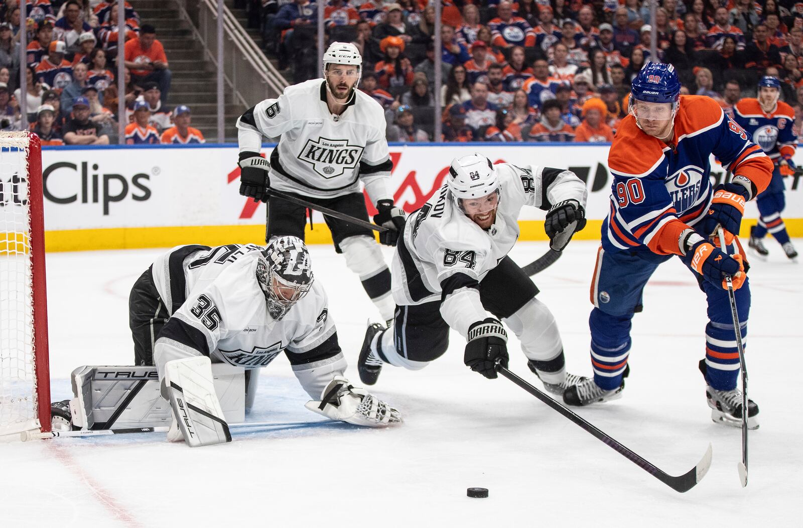 Los Angeles Kings goalie Darcy Kuemper (35) makes the save as Vladislav Gavrikov (84) and Edmonton Oilers' Corey Perry (90) reach for the rebound during the second period of an NHL playoff game in Edmonton on Sunday, April 27, 2025. (Jason Franson/The Canadian Press via AP)