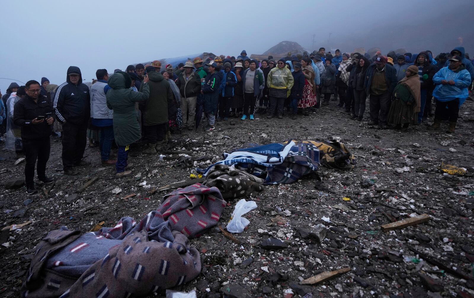 Blankets cover bodies of victims of an explosive attack near the Hijos de Ingenio gold mine in Yani, Bolivia, Thursday, April 3, 2025. (AP Photo/Juan Karita)
