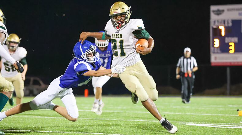 Catholic Central High School junior Darrien Stapleton (21) runs past Grove City Christian's Jaylin Walker during their game on Saturday night in Grove City. The Irish won 55-7. CONTRIBUTED PHOTO BY MICHAEL COOPER