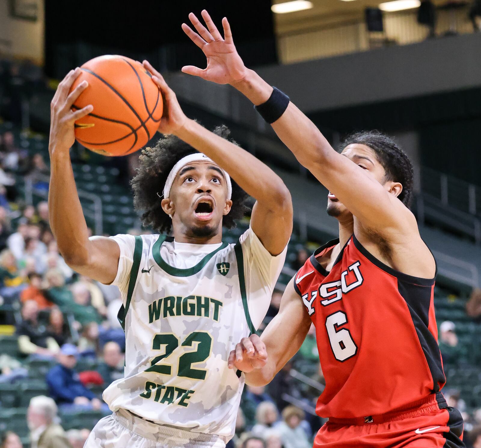 Wright State sophomore guard TJ Burch shoots with pressure from Youngstown State's Drew King during a Horizon League game on Thursday, Jan. 15 at Ervin J. Nutter Center. Burch led the Raiders with 24 points, seven assists and four steals in a 93-83 win, which is the team's seventh consecutive. BRYANT BILLING/STAFF
