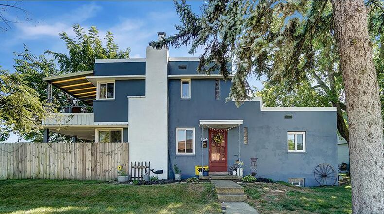 The front of the home has a concrete walkway that leads to the front door with a covered stoop. The home has painted concrete block exterior and a chimney to the decorative fireplace in the great room. There are several mature trees around the home. CONTRIBUTED PHOTO