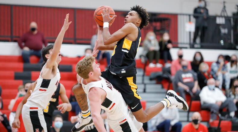 Cutline: Shawnee High School senior Jamon Miller leaps into Jonathan Alder's Jackson Izzard during their game on Friday night in Plain City. Miller scored 10 points for the Braves. CONTRIBUTED PHOTO BY MICHAEL COOPER