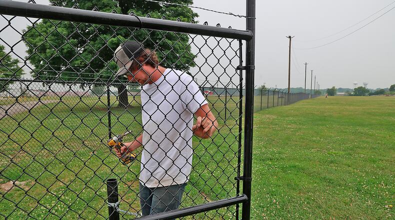 Clayton Branch, from the Springfield Fence Company, works on the new fence at the Clark County Fairgrounds Monday, June 20, 2023. The new fence separates the new general admission parking area from the rest of the fairgrounds. Fairgoers will park their car and walk through a gate where they will pay admission. BILL LACKEY/STAFF