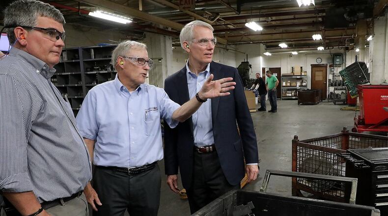 Andrew Brougher and Dan McGregor, from the Morgal Machine Tool Company, talk about the manufacturing plant’s production with Senator Rob Portman during a tour of the facility Tuesday. BILL LACKEY/STAFF