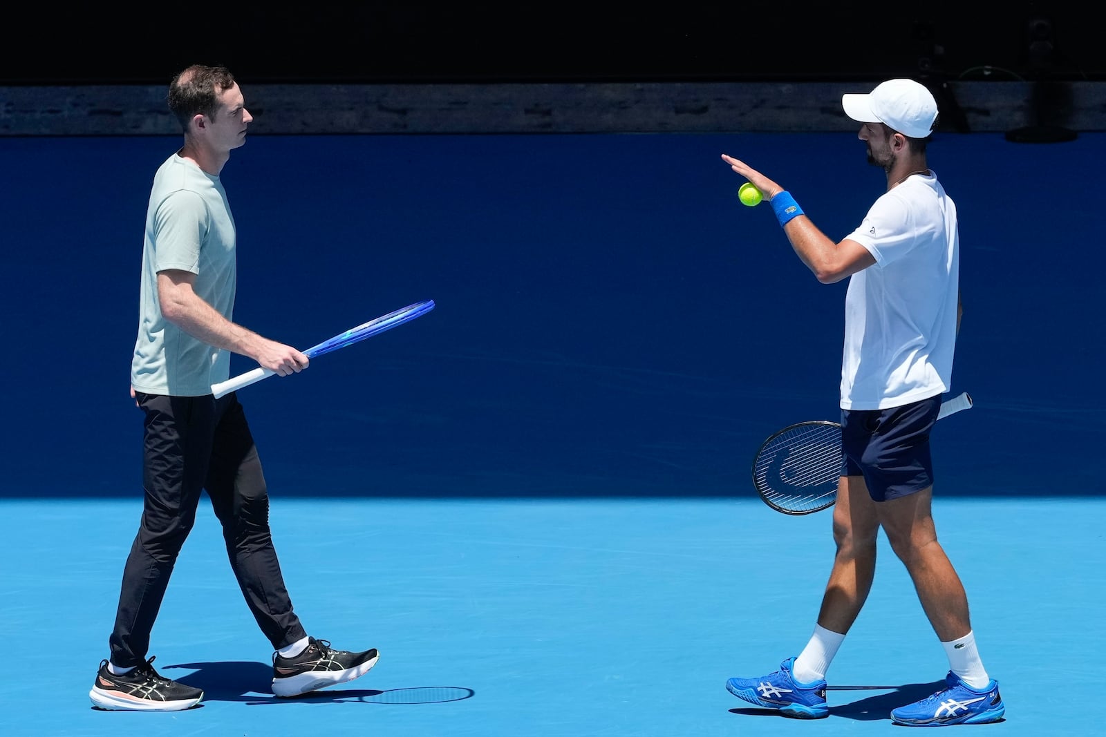 FILE - Serbia's Novak Djokovic talks with his coach Andy Murray, left, during a practice session ahead of the Australian Open tennis championship in Melbourne, Australia, Saturday, Jan. 11, 2025. (AP Photo/Manish Swarup, file)