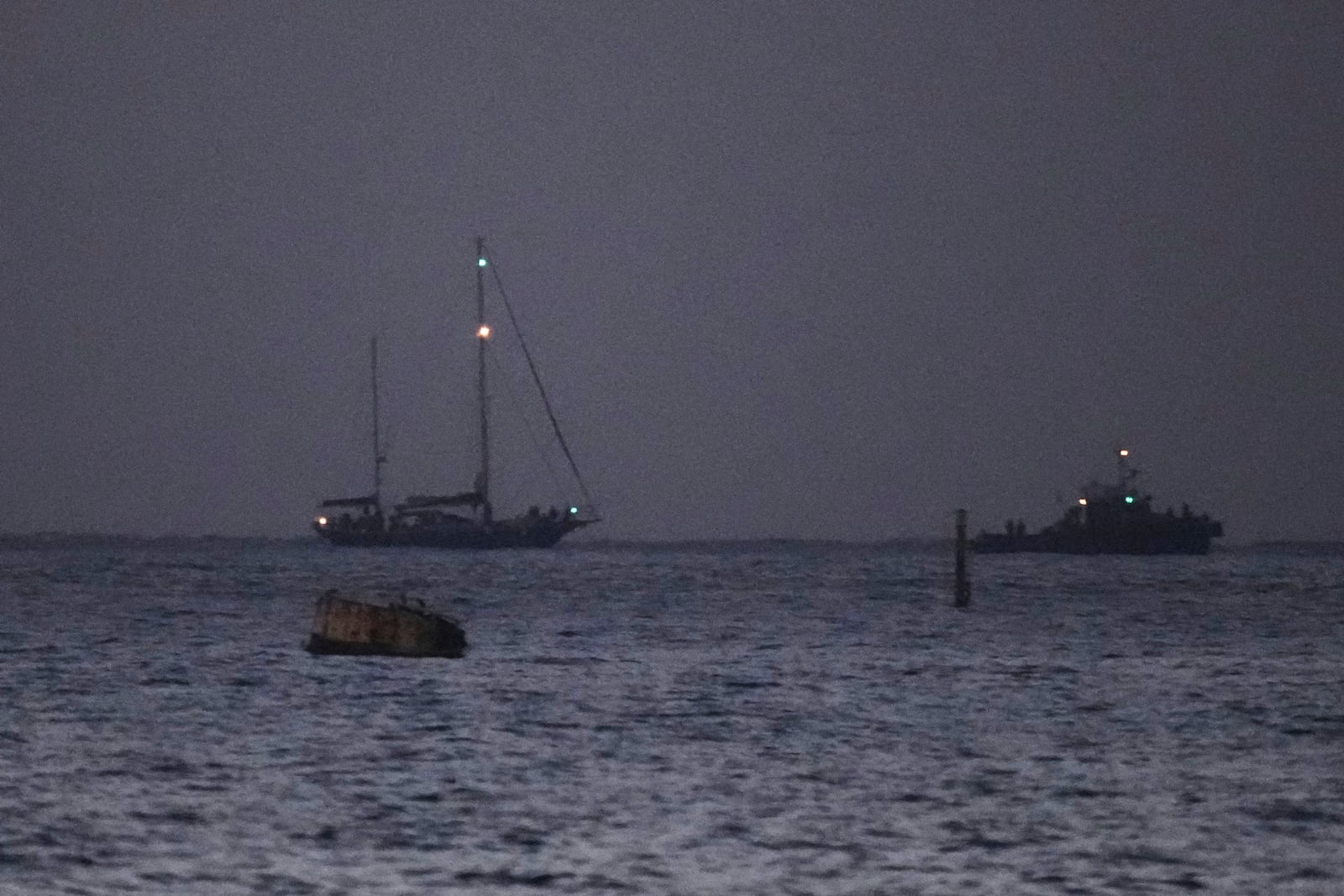 The Gaza-bound aid boat, Madleen, left, under escort of Israeli naval forces making its way toward Ashdod Port in southern Israel after being seized by Israeli forces, Monday, June 9, 2025. (AP Photo/Leo Correa)