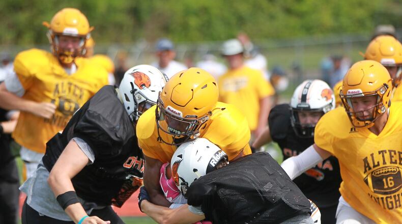 Alter High School sophomore C.J. Hicks makes a short gain during a preseason scrimmage at Beavercreek. Alter defeated Fairmont 21-7 and Beavercreek defeated Xenia 21-20 in Thursday Week 1 openers. MARC PENDLETON / STAFF