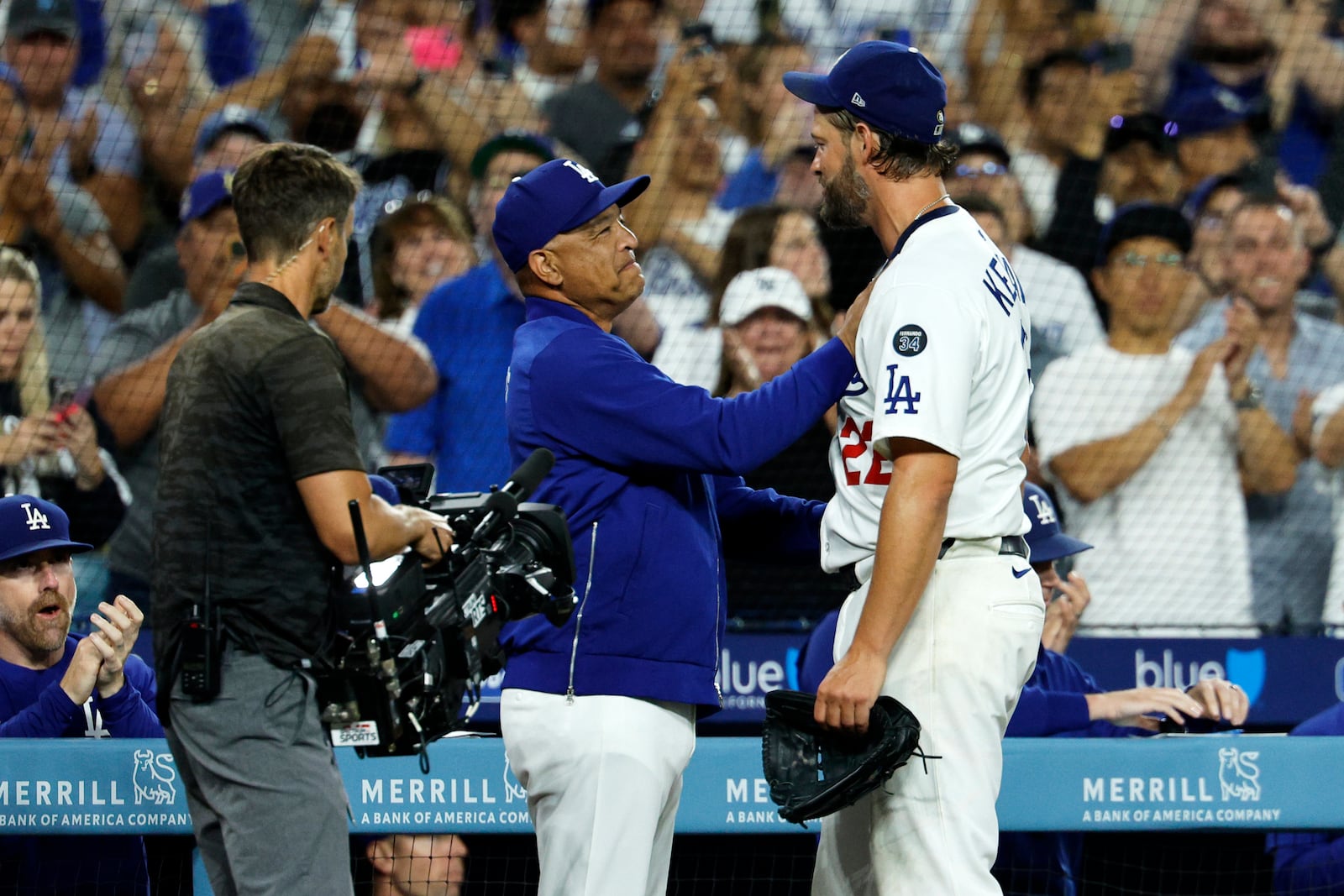 Los Angeles Dodgers pitcher Clayton Kershaw, right, is congratulated by Dodgers manager Dave Roberts, center, after recording his 3,000th career strikeout during the sixth inning of a baseball game against Chicago White Sox Wednesday, July 2, 2025, in Los Angeles. (AP Photo/Kevork Djansezian)