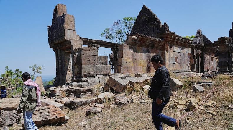 Cambodian police officers walk past a temple damaged during border clashes with Thailand, at Preah Vihear province, Cambodia, Saturday, March 14, 2026, (AP Photo/Heng Sinith)