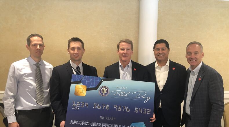 Ohio Lt. Gov. Jon Husted (center), JobsOhio President JP Nauseef (second from the right), Dayton Development Coalition President and CEO Jeff Hoagland (far right), with representatives from Utah-based IMSAR celebrating a newly awarded contract. CONTRIBUTED