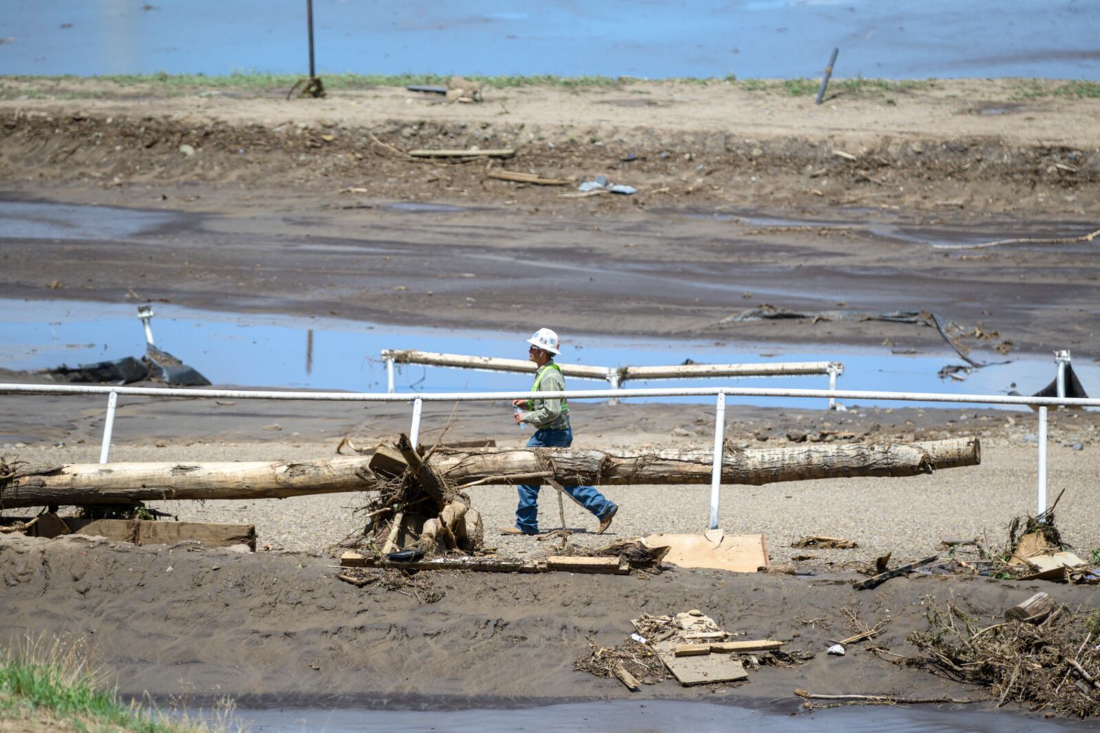 A man crosses the Ruidoso Downs Racetrack which was partially destroyed after the flood, Wednesday, July 9, 2025, Ruidoso, N.M. (AP Photo/Roberto E. Rosales)