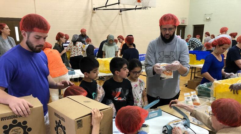 Members of the Masjid Al-Madina Mosque worked alongside members of Central Christian Church and others from the community to pack meals for Ukrainian refugees on Sunday.