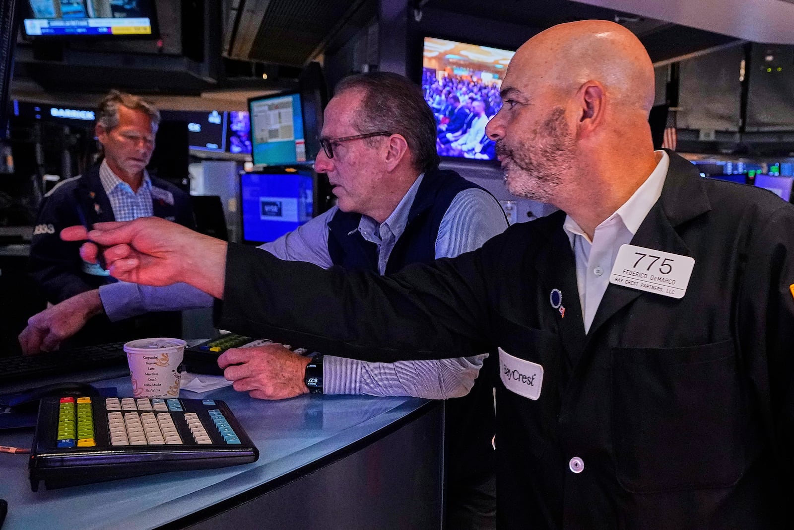 Specialist Glenn Carell, center, and trader Fred Demarco, right, work on the floor of the New York Stock Exchange, Friday, May 9, 2025. (AP Photo/Richard Drew)