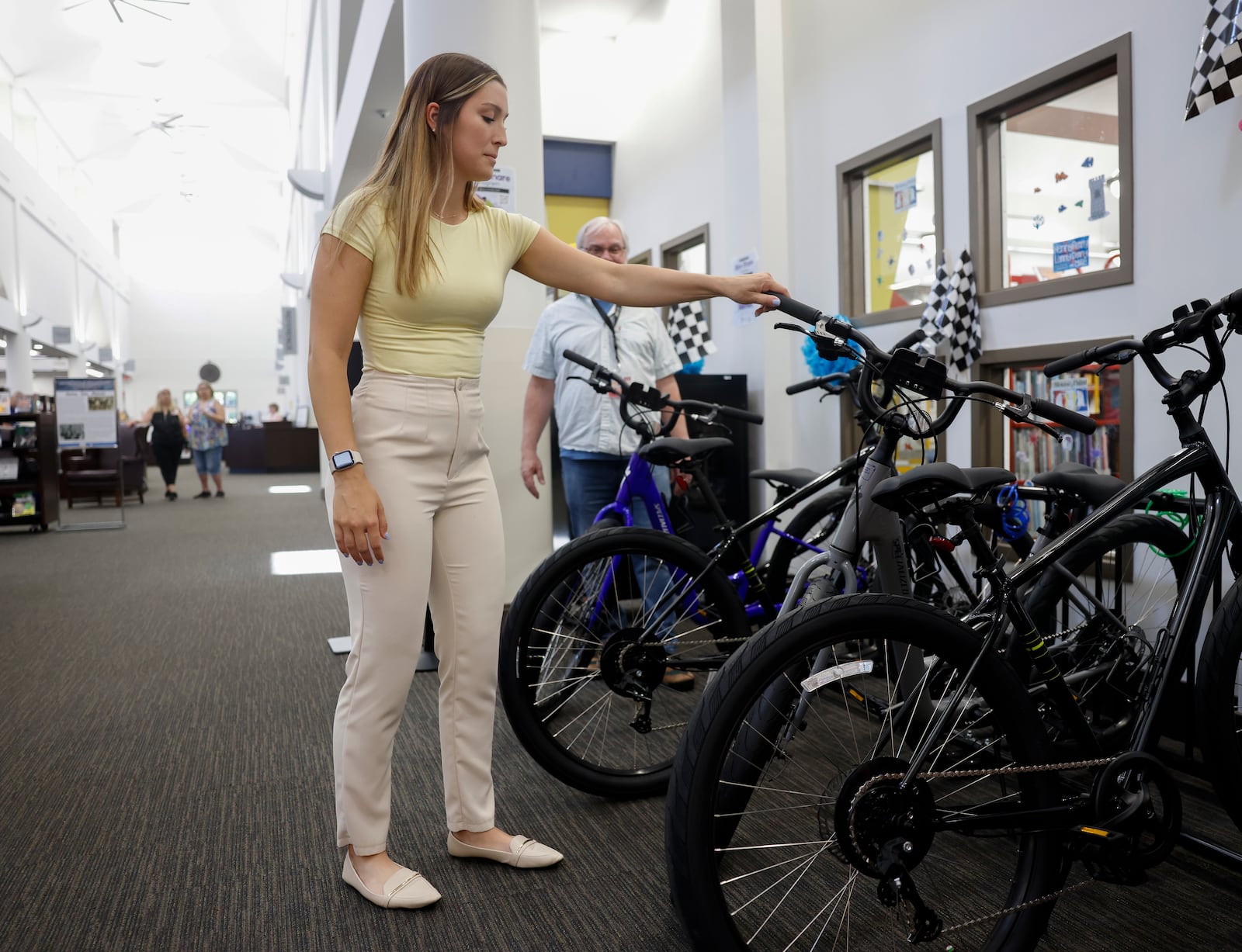 Ashley Maksvytis, creating healthy communities coordinator at Clark Combined Health District, checks out a bicycle at the kickoff of the Clark County Bikeshare program, on Monday, June 23, 2025, at the Clark County Public Library. JOSEPH COOKE/STAFF