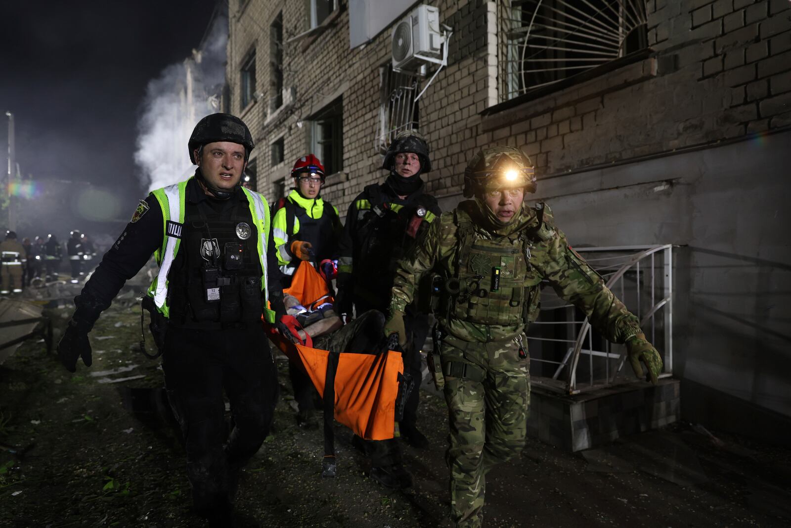 Police officers carry an injured man on a stretcher after a Russian strike on residential neighbourhood in Zaporizhzhia, Ukraine, Thursday, May 1, 2025. (AP Photo/Kateryna Klochko)