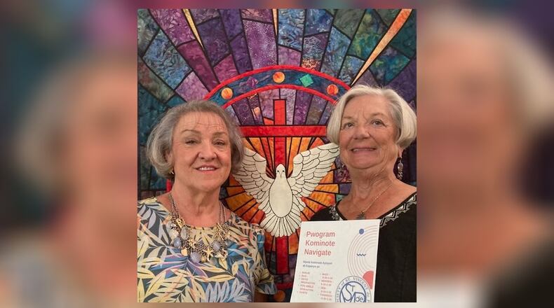 Nurse Connie Mitchell, right, holds a Creole language flier with Pastor Vicki Downing in the sanctuary of Springfield's Grace United Methodist Church. (Photo: 
 TOM STAFFORD)