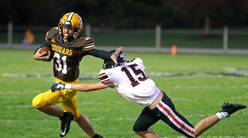 Kenton Ridge’s Carson Jones tries to avoid a tackle by Jonathan Alder’s Jonathan Keth. BILL LACKEY/STAFF