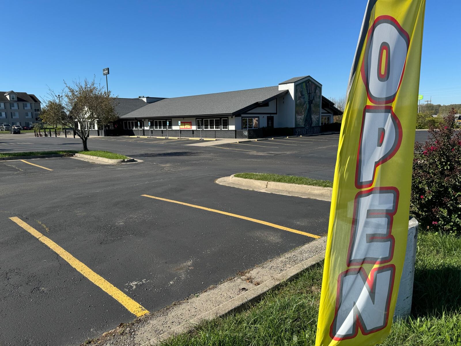 An “OPEN” banner waves in the wind outside Mango’s Lounge but the doors are chained shut Thursday, Oct. 10, 2024. BILL LACKEY/STAFF