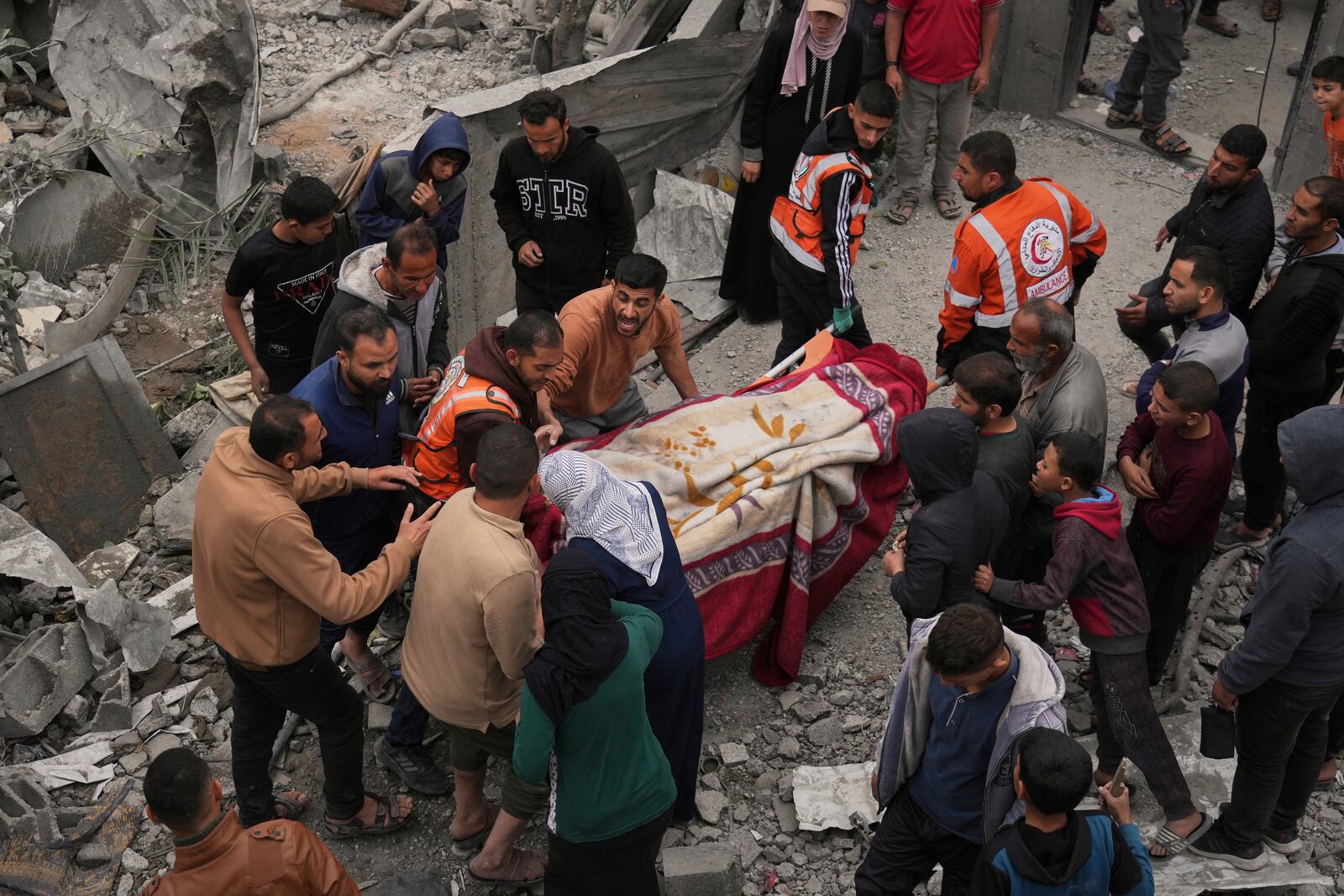 Volunteers and emergency workers remove a body from the rubble of the Manoun family's house after it was targeted by an Israeli army strike in Jabalia al-Balad, Gaza City, Sunday, April 13, 2025. (AP Photo/Jehad Alshrafi)
