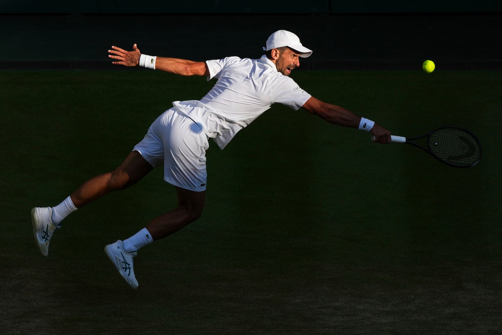 Serbia's Novak Djokovic returns to Italy's Flavio Cobolli during a quarterfinal men's singles match at the Wimbledon Tennis Championships in London, Wednesday, July 9, 2025. (AP Photo/Joanna Chan)