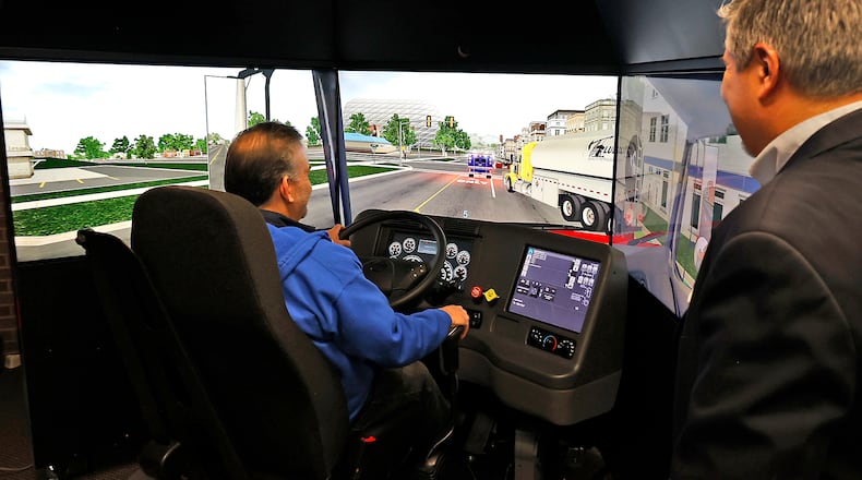 William Weekley, training manager of the Clark State College CDL program, demonstrates the different programs and scenarios that can be loaded into the new truck driving simulator Tuesday, Feb. 21, 2023 during an open house. BILL LACKEY/STAFF