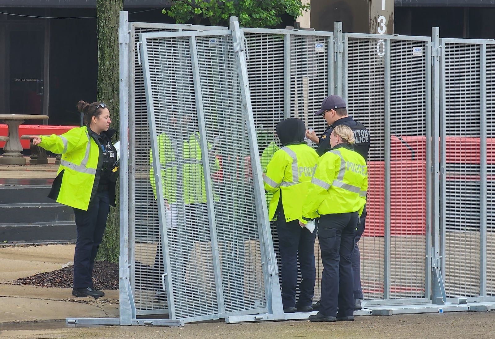 Dayton Police attach warnings to fencing being installed for NATO event in downtown Dayton Tuesday, May 20, 2025. NICK GRAHAM/STAFF