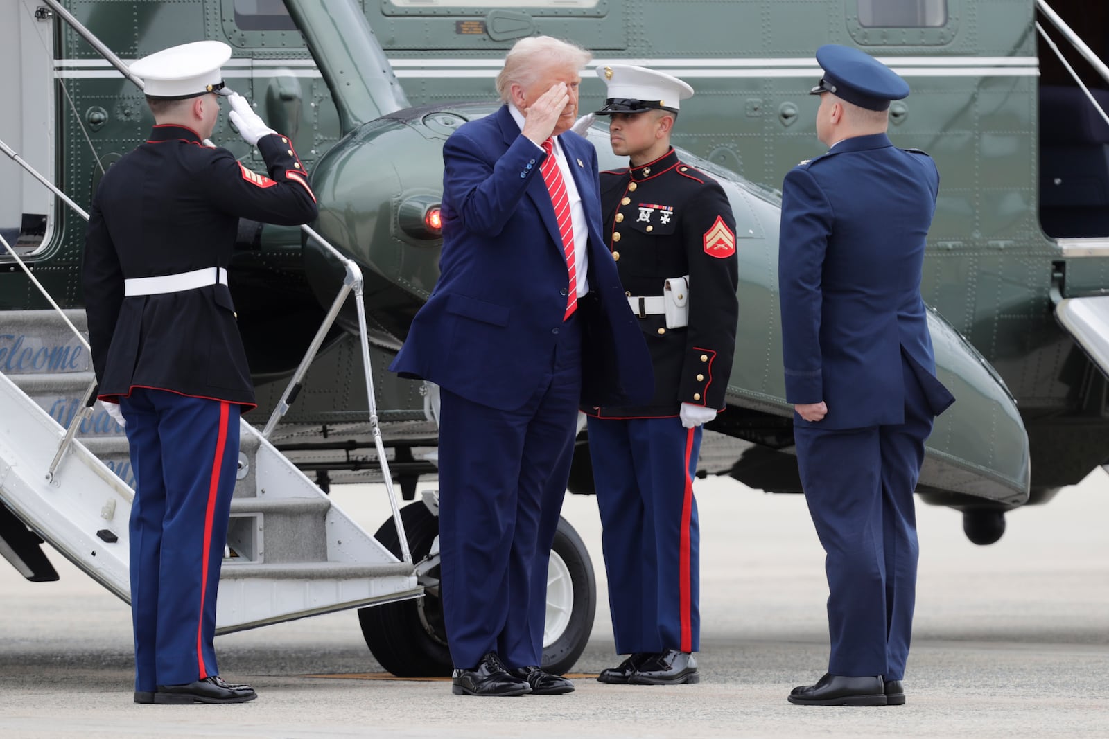 President Donald Trump, center, is greeted by Col. Paul Pawluk, Vice Commander, 89th Airlift Wing, right upon his arrival at Joint Base Andrews, Md., Friday, May 30, 2025. (AP Photo/Luis M. Alvarez)