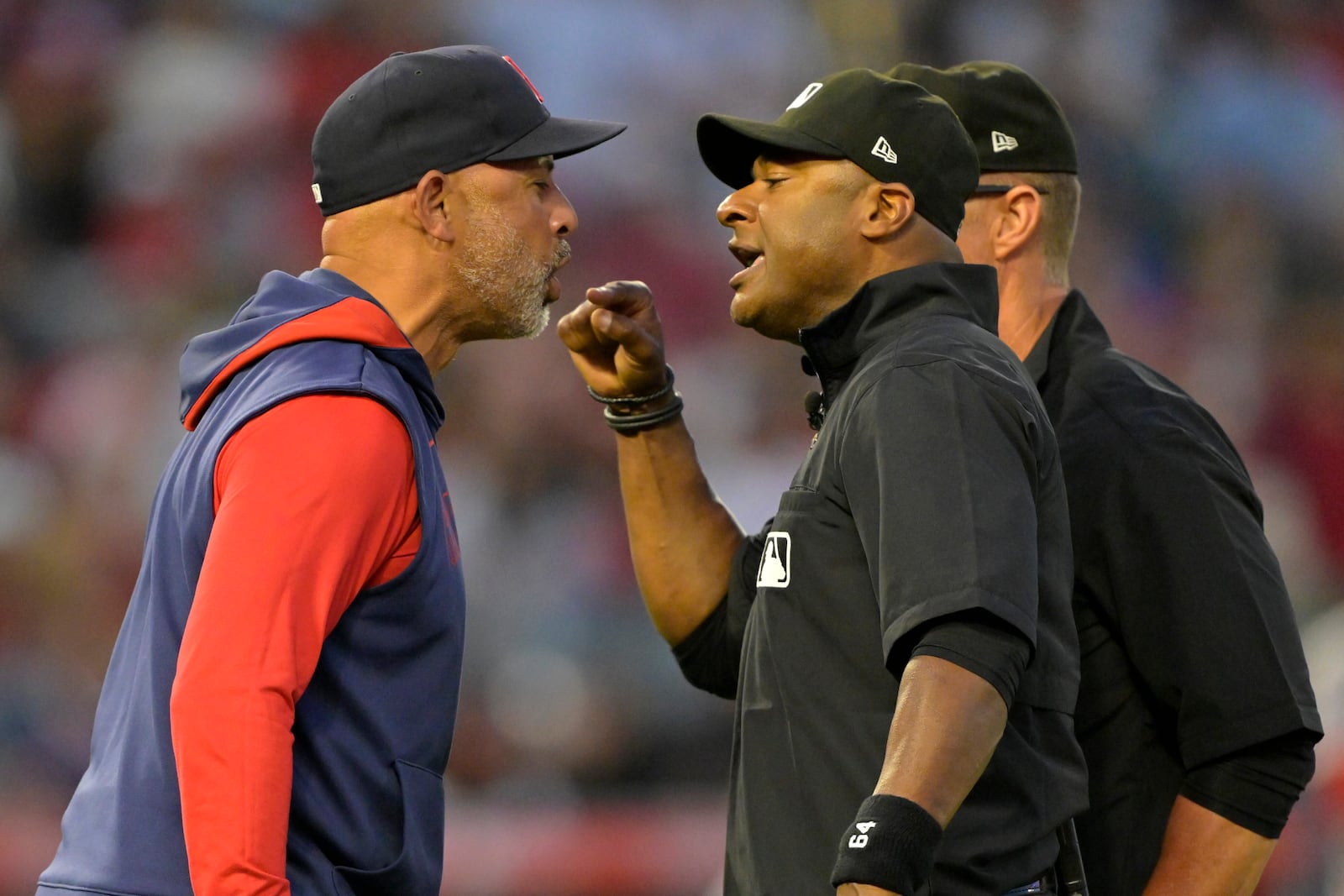 Boston Red Sox manager Alex Cora, left, argues with umpire Alan Porter, front right, as umpire Jim Wolf, back right, looks on after he was ejected in the fifth inning during a baseball game against the Los Angeles Angels, Monday, June 23, 2025, in Anaheim, Calif. (AP Photo/Jayne Kamin-Oncea)