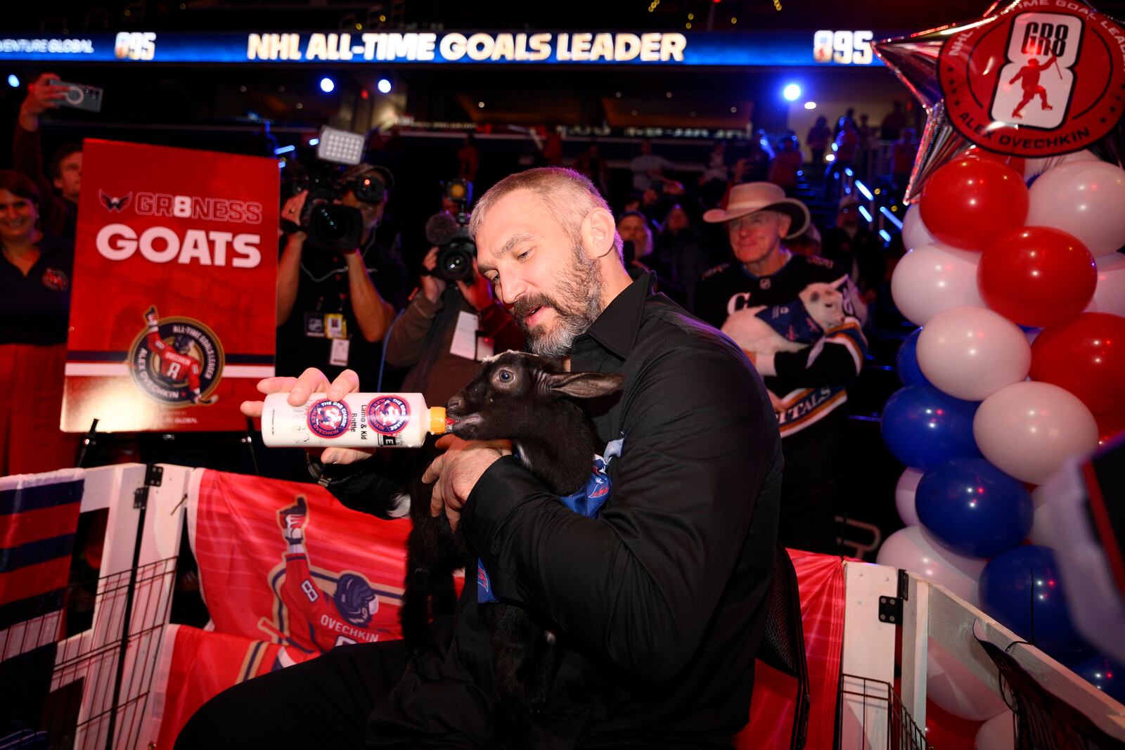 Washington Capitals left wing Alex Ovechkin feeds a goat as he takes part in the GR8 city celebration to honor him for scoring 895 NHL hockey career goals, Friday, April 11, 2025, in Washington. (AP Photo/Nick Wass)